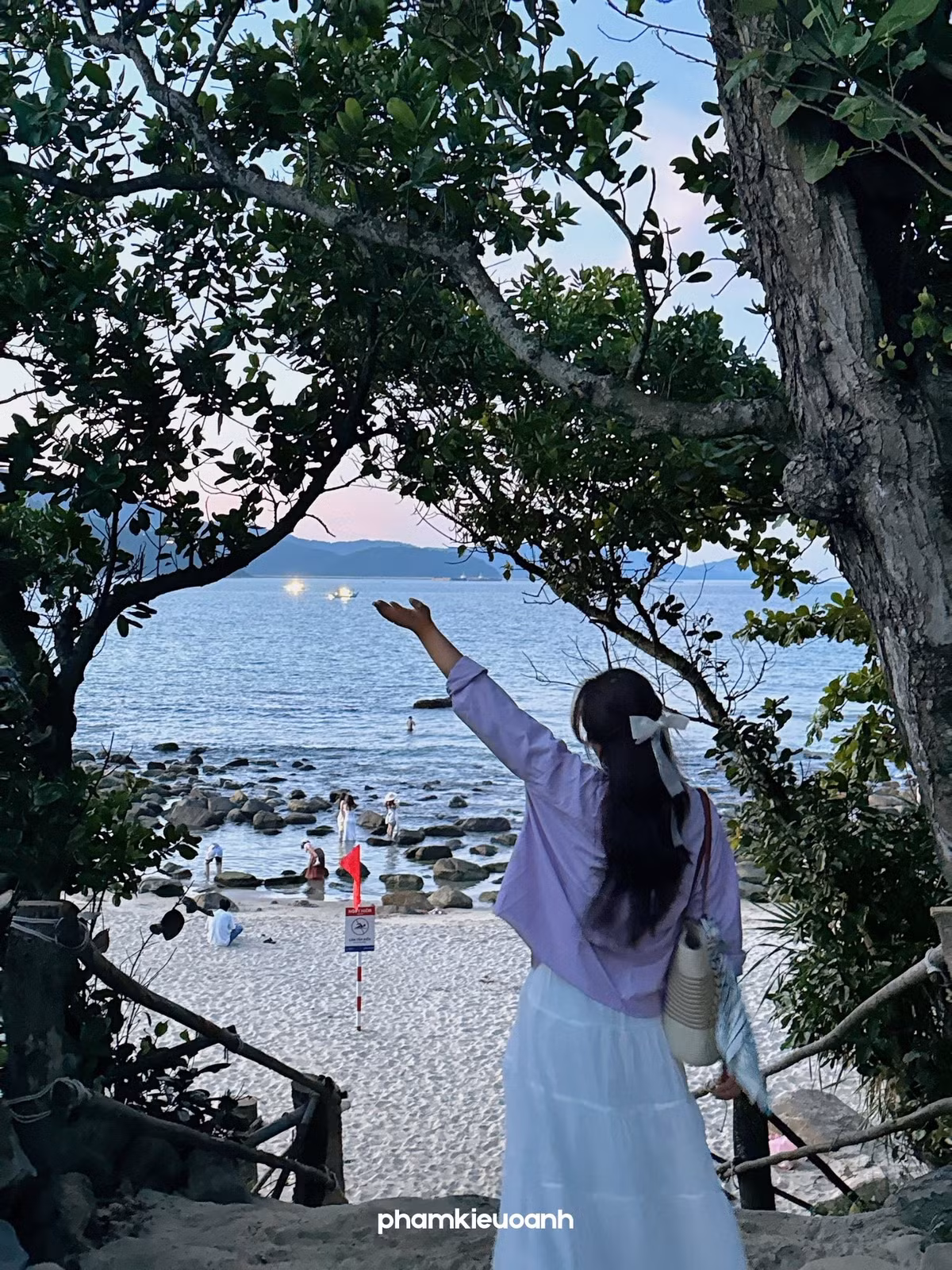 Không chỉ bãi đá phủ rêu mới thu hút, chính con đường mòn dẫn xuống bãi rêu Nam Ô cũng là một “background” sống ảo đầy chất thơ. Đây là đoạn lối nhỏ uốn lượn quanh lùm cây ven biển, với một bên là tường đá cũ kỹ rêu phong, bên kia là thoáng nhìn ra đại dương xanh thẳm. Vào sáng sớm, ánh nắng chiếu xuyên qua tán lá tạo nên những vệt sáng loang loáng, khiến từng bước chân như đi vào một thước phim lãng mạn. Ảnh PhamKieuOanh