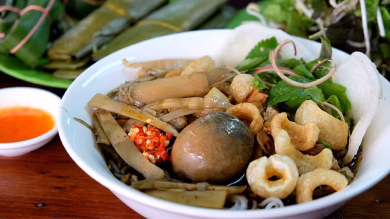 Tất cả được chan ngập trong nước dùng đen sánh, tỏa mùi “khó quên”. Khi ăn, người Gia Lai thường trộn đều, thêm ít ớt giã và chanh tươi, để hương vị hòa quyện hoàn hảo – cay nồng, béo ngậy và thoang thoảng vị chua của cua lên men. Ảnh luhanhvietnam