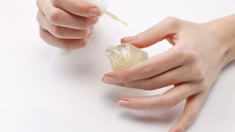 Để móng được bảo vệ tốt hơn, một lớp sơn phủ hoặc sơn nền trong suốt có thể được sử dụng. Lớp sơn này giúp móng tránh bị ố vàng, bạc màu, đồng thời tạo độ bóng và cảm giác chắc khỏe. Trước khi sơn màu, việc quét sơn nền là bước không nên bỏ qua. Ảnh minh họa