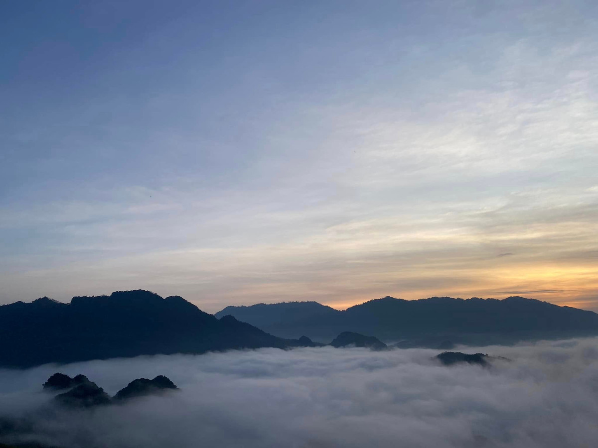 Khoảnh khắc đáng giá nhất là khi mặt trời vừa ló rạng. Mây cuộn dưới thung lũng, bản làng và ruộng nương thấp thoáng phía xa. Khi nắng lên, biển mây dần tan, để lộ bức tranh trung du với những gam màu dịu nhẹ của núi đồi và nếp nhà sàn. Ảnh Fanpage Đèo Cón Chill