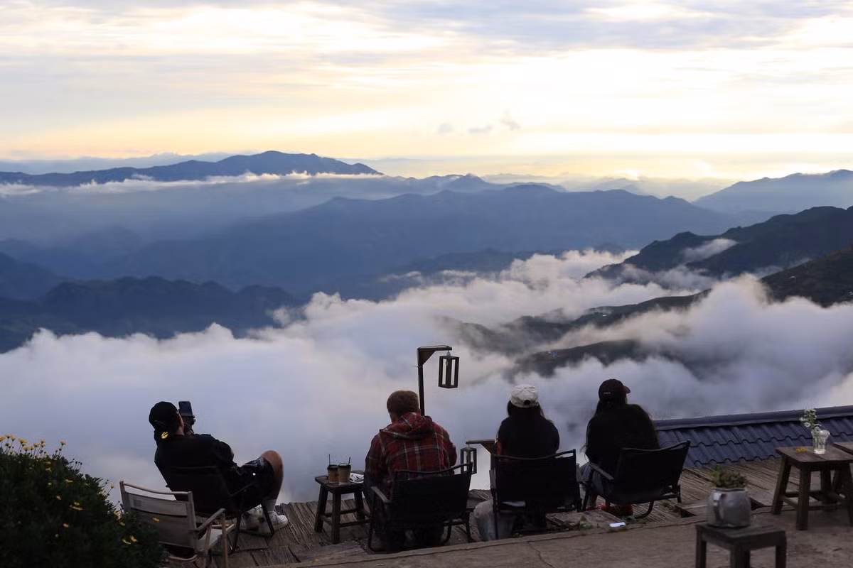 Chỉ cách Mị Ơi vài bước chân, Hiên Coffee nép mình dưới những tán cây táo mèo cổ thụ, mang vẻ mộc mạc và thân thuộc. Ánh đèn vàng ấm áp cùng tiếng gió thổi qua mái gỗ khiến nơi đây như một “hiên nhà” đúng nghĩa giữa trời mây. Ảnh Fanpage Hiên