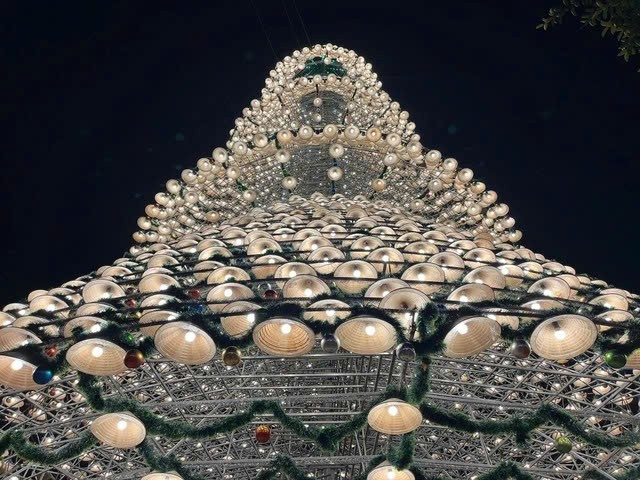 Không chỉ dừng lại ở việc trang trí, cây thông nón lá còn là minh chứng cho sự sáng tạo trong việc kết hợp truyền thống và hiện đại. Những vật liệu giản dị như nón lá được “thổi hồn” bằng ánh sáng và nghệ thuật trang trí, mang đến trải nghiệm khác biệt cho du khách. Ảnh TTXVN