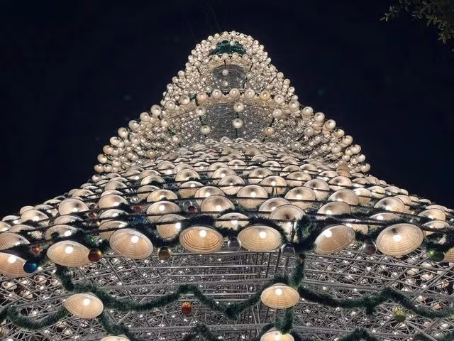 Không chỉ dừng lại ở việc trang trí, cây thông nón lá còn là minh chứng cho sự sáng tạo trong việc kết hợp truyền thống và hiện đại. Những vật liệu giản dị như nón lá được “thổi hồn” bằng ánh sáng và nghệ thuật trang trí, mang đến trải nghiệm khác biệt cho du khách. Ảnh TTXVN