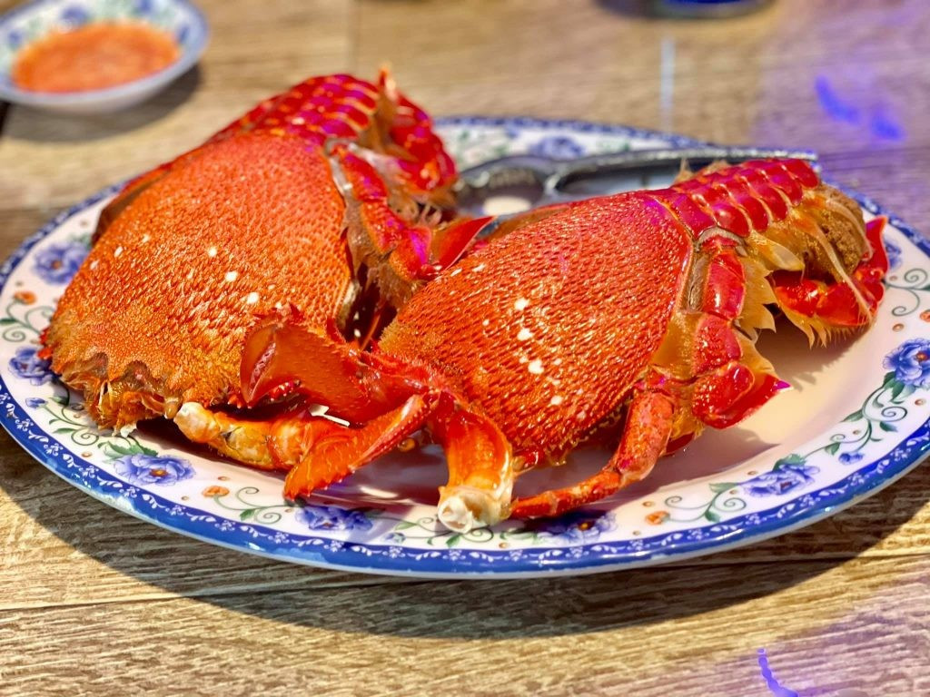 Ghé đảo Phú Quý, nhất định phải thử gỏi cá mai tươi rói, bánh căn hải sản giòn thơm, mực nướng đậm vị biển. Đặc biệt, đừng bỏ qua cua mặt trăng – loài cua vỏ hồng đốm trắng hiếm gặp, thịt ngọt chắc, hấp hay rang me đều ngon hết ý. Ảnh VinWonders