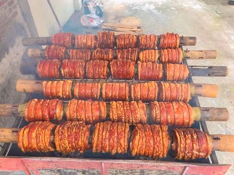 Làng cổ Đường Lâm (phường Sơn Tây, Hà Nội) không chỉ níu chân du khách bởi những ngôi nhà đá ong trăm năm tuổi hay dấu ấn lịch sử gắn với vua Ngô Quyền, mà còn bởi một món ăn dân dã nhưng vô cùng cầu kỳ: thịt quay đòn. Đây là đặc sản được người dân gìn giữ qua nhiều thế hệ, làm hoàn toàn thủ công, mỗi mẻ mất tới nửa ngày mới hoàn thành. Ảnh langcoduonglam