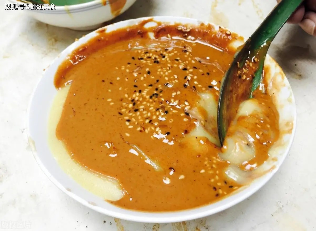 Cũng phổ biến vào buổi sáng là miến trà Bắc Kinh – món bột kê hoặc bột gạo nấu sệt, rưới sốt mè thơm béo. Dù tên gọi là “trà”, món ăn này không dùng để uống giải khát mà được bưng bát lên thưởng thức trực tiếp, mang đến cảm giác lạ miệng nhưng dễ gây “nghiện”. Ảnh Sohu