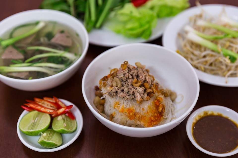 Tô phở khô trắng ngần được điểm xuyết bằng thịt băm, hành phi, tóp mỡ, đôi khi có thêm gà xé hoặc thịt bò. Linh hồn của món ăn nằm ở chén tương đen loại tương đậu nành lên men có vị mặn mà, béo nhẹ và thoảng ngọt. Khi trộn đều cùng phở, thêm rau quế, ngò gai, xà lách, vắt chút chanh và nêm ớt theo khẩu vị, tất cả hòa quyện tạo nên hương vị vừa đậm đà vừa hài hòa. Ảnh quynhonsea