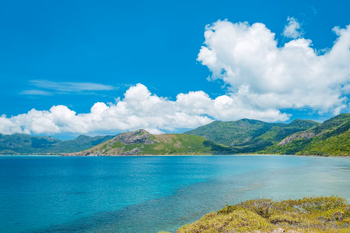 Từng khúc cua uốn lượn như dắt người lữ hành lạc vào một bức tranh thủy mặc, nơi ánh sáng mặt trời xuyên qua từng tán cây tạo nên những vệt nắng lung linh trải dài trên mặt đường. Ảnh Hồng Nhật