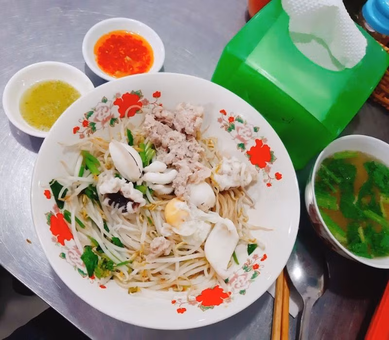 Nước dùng nấu từ mực và xương heo thơm lừng, không tanh, càng ăn càng cuốn. Trên đường Phan Xích Long (Phú Nhuận), nhiều quán hủ tiếu mực lúc nào cũng đông kín khách từ sáng sớm đến khuya. Ảnh MIA