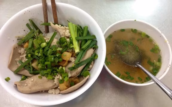 Nếu Nam Lợi mang đậm phong vị Hoa – Việt, thì quán hủ tiếu mì cật trên đường Trương Định lại là biểu tượng của sự cầu kỳ và chuẩn mực trong ẩm thực Sài Gòn. Hơn nửa thế kỷ tồn tại, quán vẫn nổi tiếng nhờ cách chế biến tinh tế: cật heo được làm sạch kỹ, cắt mỏng vừa phải để giữ độ giòn, kết hợp cùng mì sợi vàng nhạt tự làm, thịt bằm và giá hẹ xanh mướt. Ảnh Foody