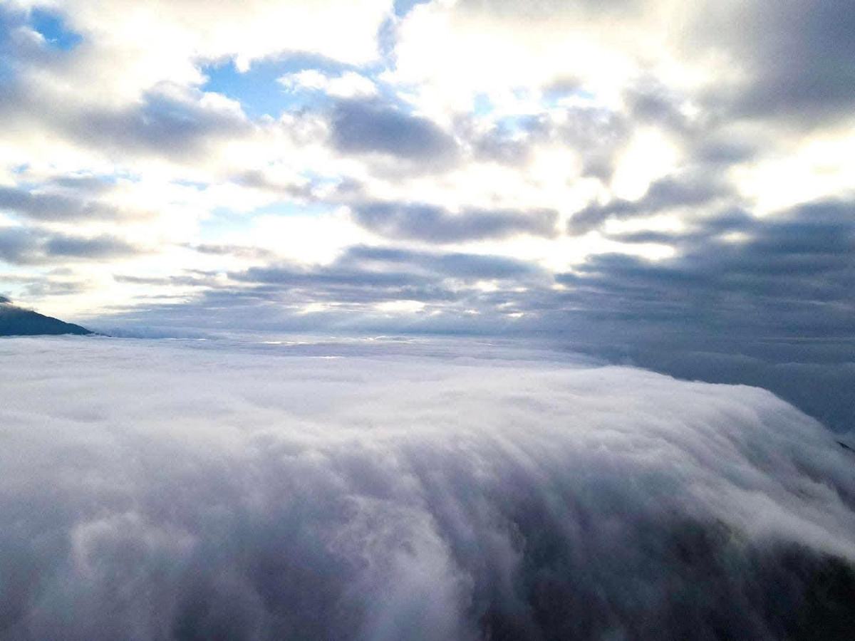 Khác với biển mây trải rộng quen thuộc, thác mây là hiện tượng mây tầng thấp dồn tụ, chuyển động rõ rệt theo địa hình, tạo cảm giác như dòng thác đang “chảy” giữa không trung. Ảnh Nhà Bên Rừng