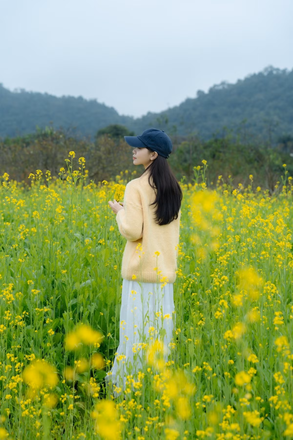 Trang phục nên chọn các gam màu sáng, trung tính như trắng, be, kem để tạo sự tương phản nhẹ với sắc vàng của hoa và khung cảnh mùa đông. Áo khoác dáng dài, khăn choàng mỏng cũng là lựa chọn phù hợp với tiết trời cao nguyên. Ảnh Huyen Chang