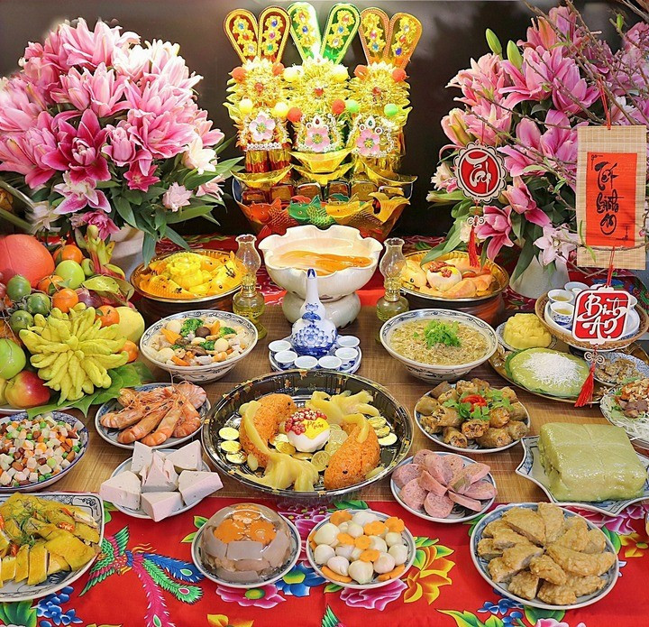 Mâm cỗ được chuẩn bị rất công phu với gà luộc, tôm hấp, nem rán, chả lụa, thịt đông, canh nóng, xôi, bánh chưng, các món nộm, rau xào và mâm hoa quả lớn. Ảnh Internet