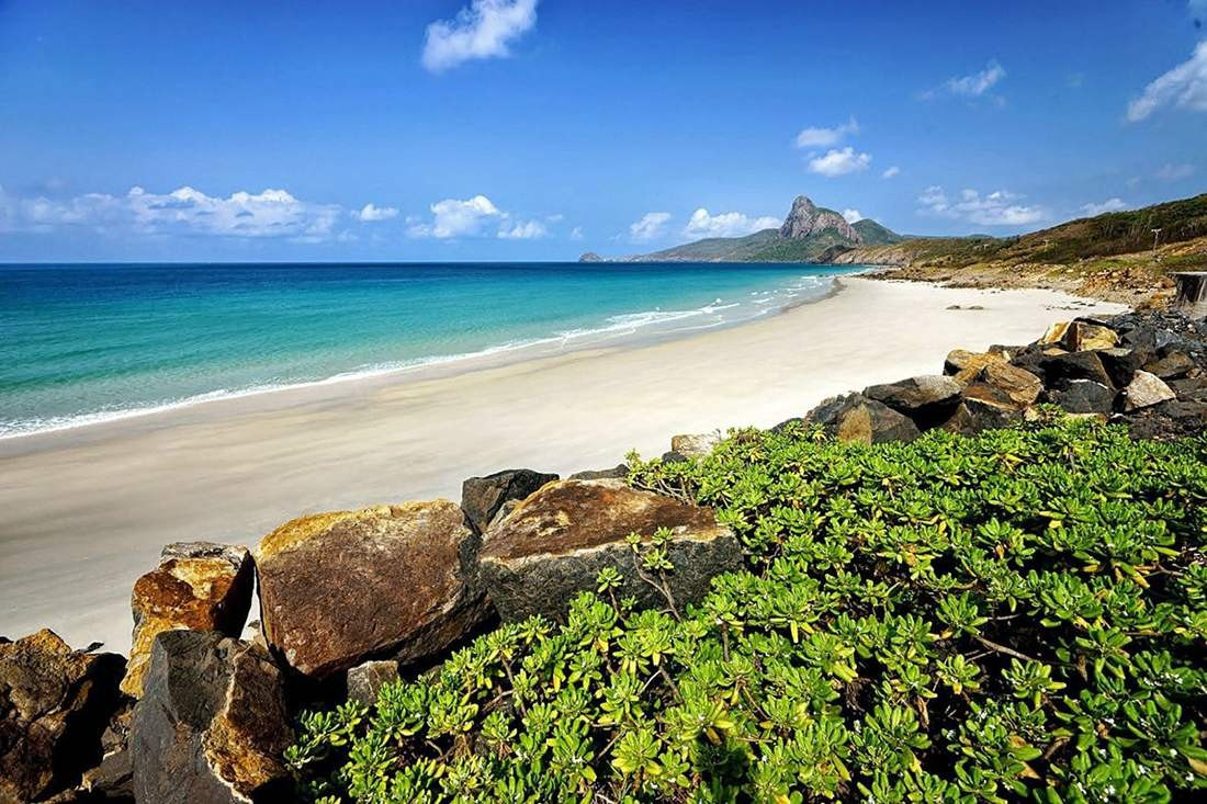 Bốn bề là núi non trập trùng tạo thành phông nền ngoạn mục cho bức tranh biển tĩnh lặng. Dưới ánh nắng chan hòa, nước biển chuyển màu xanh ngọc trong vắt, có thể nhìn thấy cả đáy. Khung cảnh ấy không chỉ khiến du khách say mê mà còn được giới chuyên môn đánh giá cao. Ảnh MIA