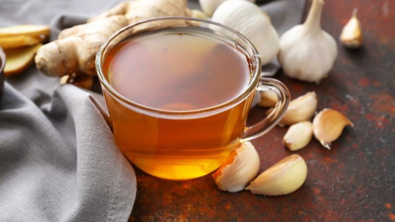 Với những người không quen ăn tỏi sống, trà tỏi là lựa chọn nhẹ nhàng hơn. Cách pha khá đơn giản: nghiền nát một tép tỏi, cho vào một cốc nước, đun sôi vài phút rồi thêm 1–2 thìa cà phê quế. Khi nước còn ấm, cho thêm một thìa mật ong cùng nửa thìa nước cốt chanh. Ảnh minh họa