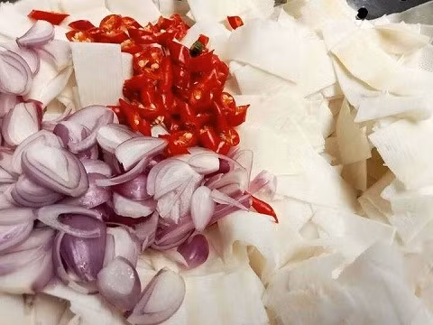 Măng, tỏi, ớt sau khi ráo sẽ được xếp vào lọ thủy tinh đã tiệt trùng, đổ nước ngâm vào đảm bảo nguyên liệu ngập hoàn toàn, sau đó đậy kín nắp. Ảnh minh họa