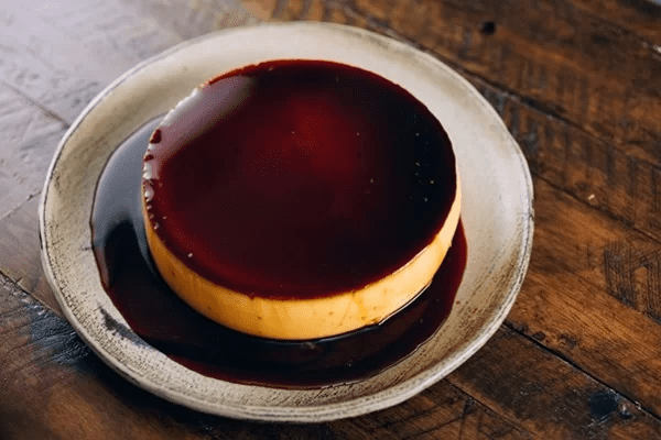 Điểm khác biệt nằm ở cách thưởng thức: flan thường được rưới thêm cà phê đen. Vị đắng nhẹ của cà phê giúp cân bằng độ ngọt và béo của trứng sữa, tạo nên tổng thể hài hòa, phù hợp với khẩu vị của nhiều thực khách. Ảnh Internet