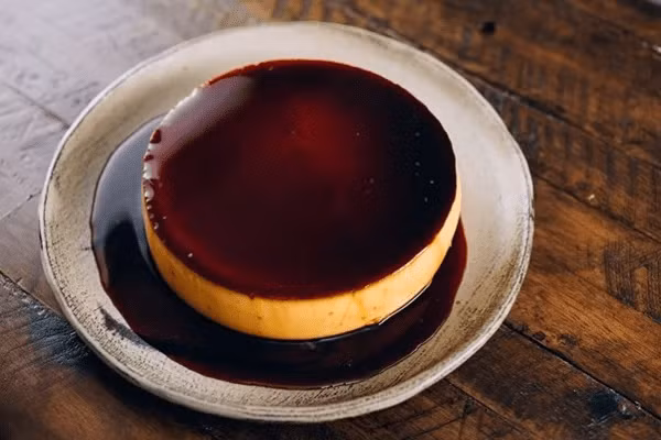 Điểm khác biệt nằm ở cách thưởng thức: flan thường được rưới thêm cà phê đen. Vị đắng nhẹ của cà phê giúp cân bằng độ ngọt và béo của trứng sữa, tạo nên tổng thể hài hòa, phù hợp với khẩu vị của nhiều thực khách. Ảnh Internet