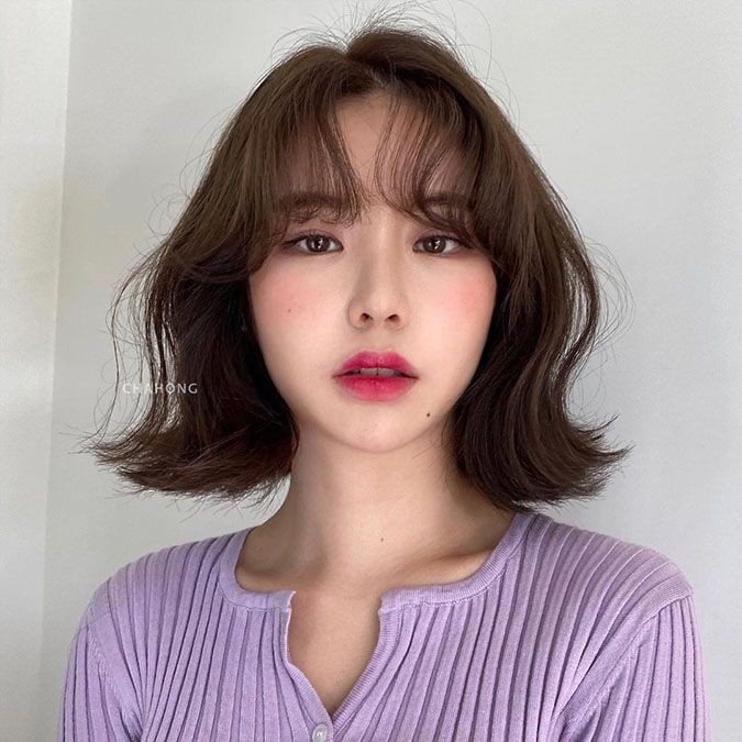 Phần đuôi tóc uốn vểnh nhẹ không chỉ che khéo các khuyết điểm như gò má cao hay thái dương hóp mà còn giúp gương mặt trông đầy đặn, hài hòa hơn. Chiều dài chạm xương quai xanh còn tạo hiệu ứng cổ cao và thon, góp phần giúp vóc dáng tổng thể trở nên thanh thoát. Ảnh minh họa