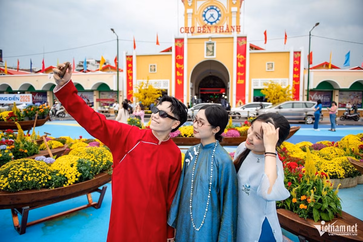 Mặc dù còn nhiều ý kiến trái chiều về màu sơn hình sóng nước, nhưng ngay trong ngày đầu “mở rào”, khu vực phía trước Chợ Bến Thành liên tục đón dòng người đổ về tham quan. Phần mái ngói đỏ đặc trưng đã được lợp hoàn chỉnh, quảng trường được chỉnh trang đồng bộ, tạo nên không gian thoáng đãng, sáng sủa hơn so với trước. Ảnh Báo Vietnamnet