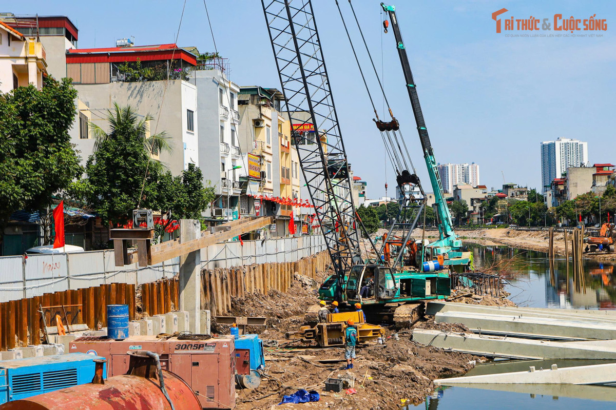 Tại công trường, nhiều mũi thi công được triển khai đồng loạt. Các thiết bị chuyên dụng như cần cẩu, máy đào, hệ thống ép cọc và các thiết bị phục vụ thi công kè sông hoạt động liên tục dọc tuyến.