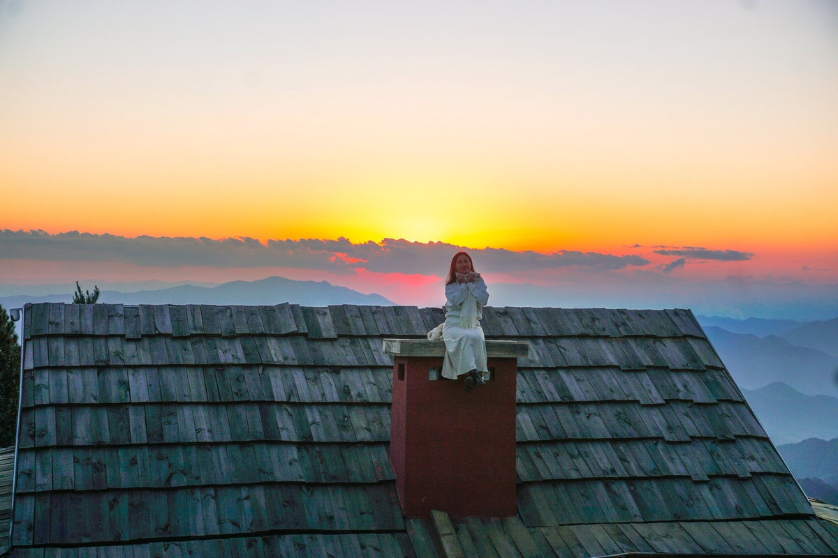 Điểm check-in này nằm tại một quán cà phê nhỏ của người dân địa phương, được xây dựng tận dụng địa hình tự nhiên. Phần mái gỗ nhô ra phía thung lũng, mở ra tầm nhìn thoáng rộng, nơi mây thường xuyên cuộn trào vào buổi sáng sớm hoặc lững lờ trôi khi chiều xuống.