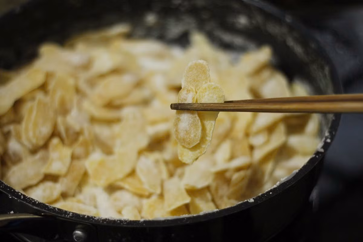 Tiếp tục sên trên lửa nhỏ cho đến khi đường bắt đầu kết tinh thành những hạt li ti bám quanh vành chảo và đầu đũa. Tắt bếp, đảo nhanh tay để mứt tơi ra, để nguội hoàn toàn rồi cho vào hũ thủy tinh bảo quản dùng dần. Ảnh minh họa/Nguồn internet