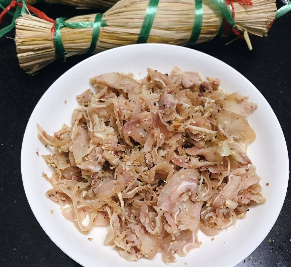 Sau khi hỗn hợp thịt ngấm gia vị, người làm bắt đầu gói tré trong lá chuối hoặc lá ổi già. Riêng tré Gia Lai thường được gói bằng lá ổi để tạo mùi thơm đặc trưng, đồng thời giúp món ăn bớt ngấy. Bên ngoài, tré được bọc thêm lớp nilon, rồi phủ rơm khô – chi tiết làm nên “thương hiệu” cho món đặc sản này. Ảnh Bazantravel