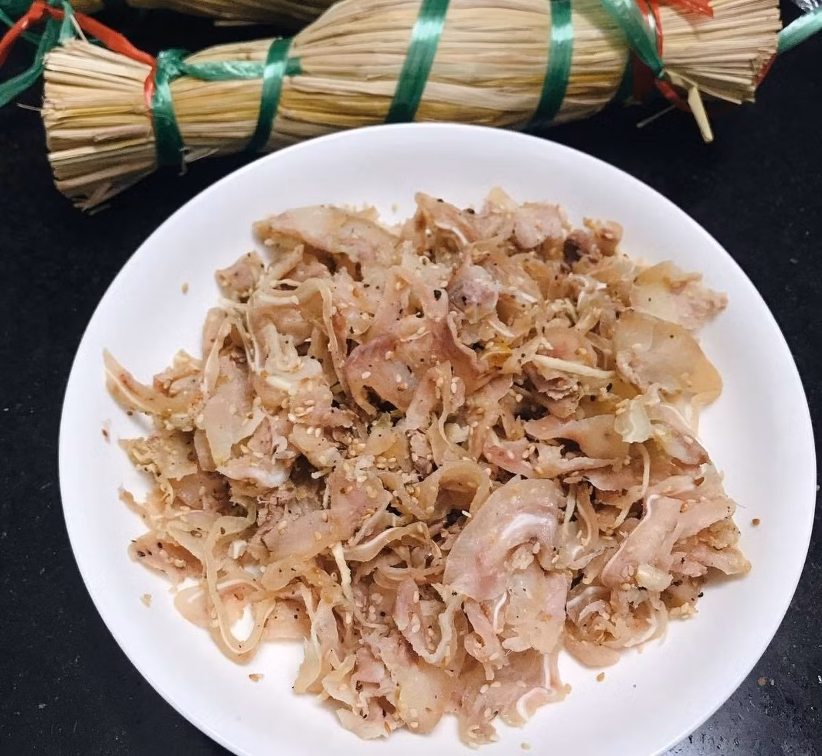 Sau khi hỗn hợp thịt ngấm gia vị, người làm bắt đầu gói tré trong lá chuối hoặc lá ổi già. Riêng tré Gia Lai thường được gói bằng lá ổi để tạo mùi thơm đặc trưng, đồng thời giúp món ăn bớt ngấy. Bên ngoài, tré được bọc thêm lớp nilon, rồi phủ rơm khô – chi tiết làm nên “thương hiệu” cho món đặc sản này. Ảnh Bazantravel