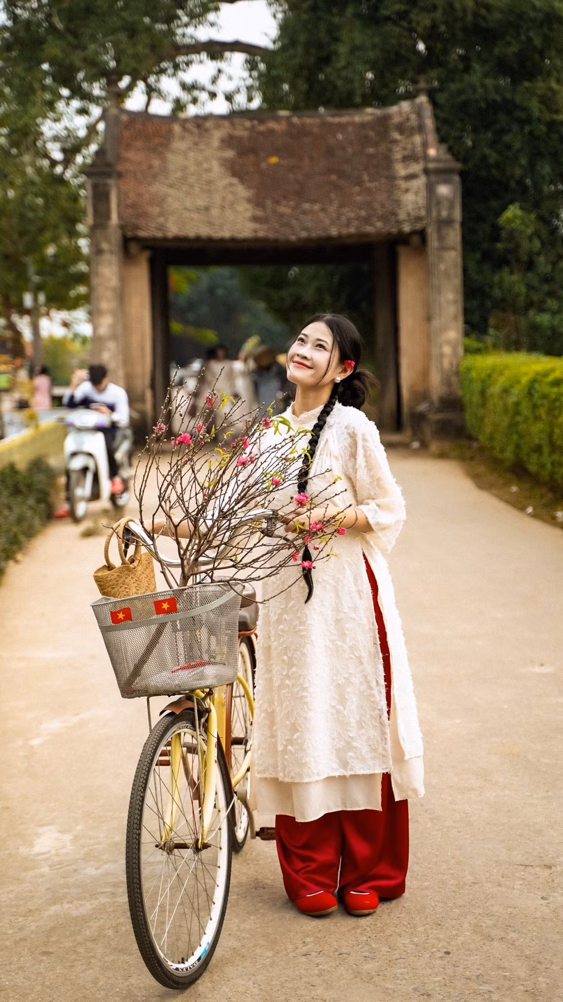 Cổng nhà cổ, cửa gỗ bạc màu theo năm tháng lại giúp tôn lên nét dịu dàng, kín đáo của tà áo dài. Bên cạnh đó, sân đình, bến nước hay những đoạn đường làng rợp bóng cây cũng là nơi lý tưởng để ghi lại những bước chân chậm rãi trong không khí giáp Tết.