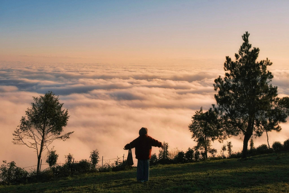 Để thưởng trọn khoảnh khắc ấy, du khách nên chọn điểm ngắm ở vị trí đồi cao – nơi có tầm nhìn bao quát không gian núi rừng trùng điệp. Khi mặt trời dần đổi sắc từ vàng cam sang đỏ thẫm, ánh sáng phản chiếu lên lớp mây dày khiến toàn bộ đường chân trời nhuốm màu rực rỡ.
