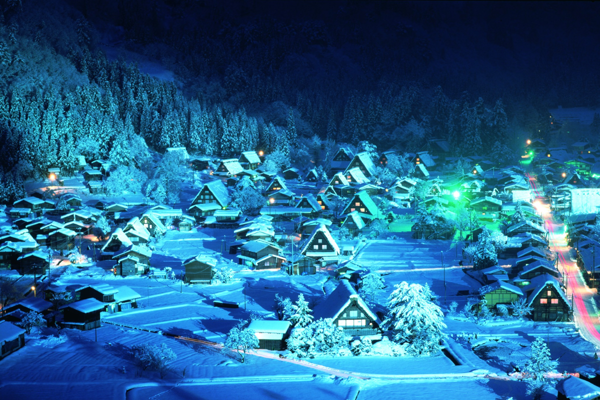 Khi đêm xuống, ánh đèn vàng hắt ra từ các ngôi nhà gỗ cổ kính phản chiếu trên nền tuyết trắng, biến ngôi làng thành một bức tranh lung linh và đầy mê hoặc. Ảnh Vietravel