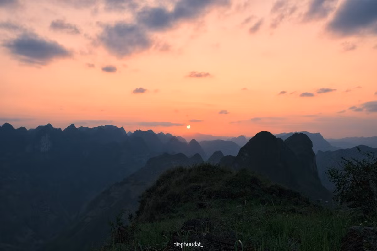 Không còn cái nắng gắt gao của ban trưa, cao nguyên đá trở nên mềm mại, dịu dàng và gần gũi đến lạ. Trong ánh chiều tà, khung cảnh hiện lên tĩnh lặng và sâu lắng, như một bức tranh thủy mặc đang chuyển mình giữa ngày và đêm. Ảnh Diệp Hữu Đạt