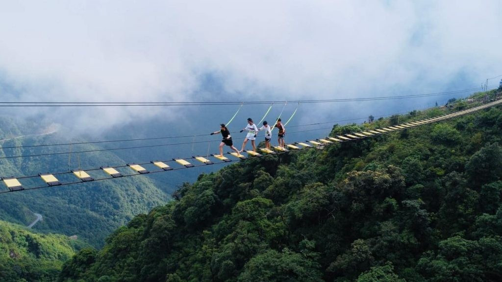 Vào những ngày đẹp trời, đứng trên cầu có thể thu trọn toàn cảnh núi rừng Tây Bắc hùng vĩ; còn khi mây kéo về, nơi đây như chìm trong biển mây bồng bềnh, tạo cảm giác lạc bước giữa chốn tiên cảnh. Ảnh Khu du lịch Cổng Trời Ô Quy Hồ