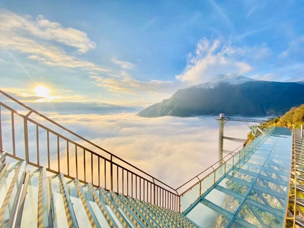 Từ khu vực thang máy, cầu kính Rồng Mây vươn mình ra khỏi vách đá với phần cầu nhô dài khoảng 60 m, tổng chiều dài toàn tuyến lên tới gần 600 m. Mặt cầu làm bằng kính cường lực trong suốt, cho phép du khách nhìn thẳng xuống vực sâu hun hút bên dưới. Ảnh Khu du lịch Cổng Trời Ô Quy Hồ