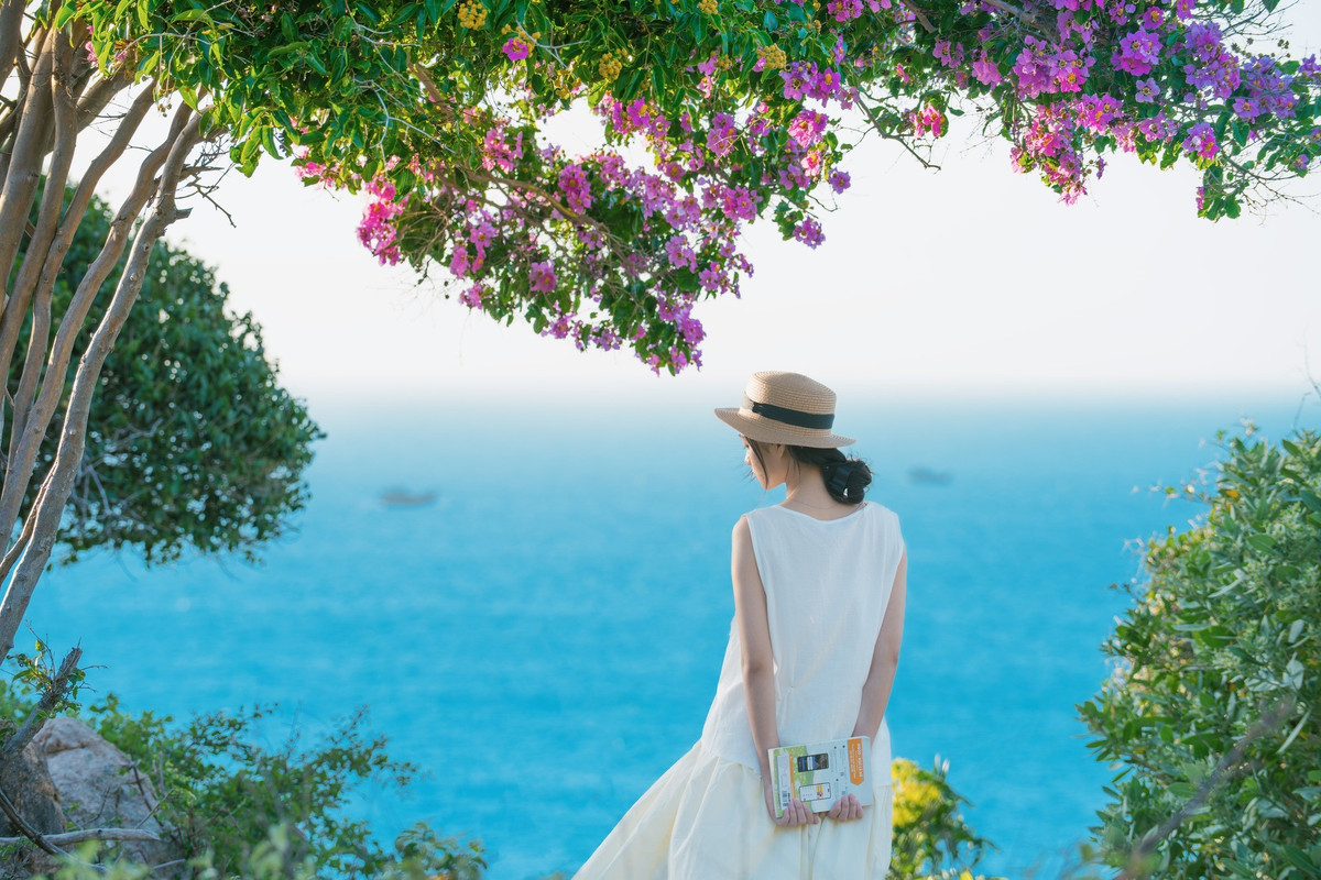 Mỹ Duyên (du khách từ TP HCM) chia sẻ: “Tôi từng đến Mũi Dinh nhiều lần, nhưng đây là lần đầu thấy nơi này rực rỡ đến vậy. Bằng lăng tím nở đầy dọc đường đi, nhìn từ xa như có sương khói mờ ảo. Mình và bạn bè tranh thủ dừng xe, chụp ảnh cả buổi chiều không chán”. Ảnh Trần Mỹ Duyên