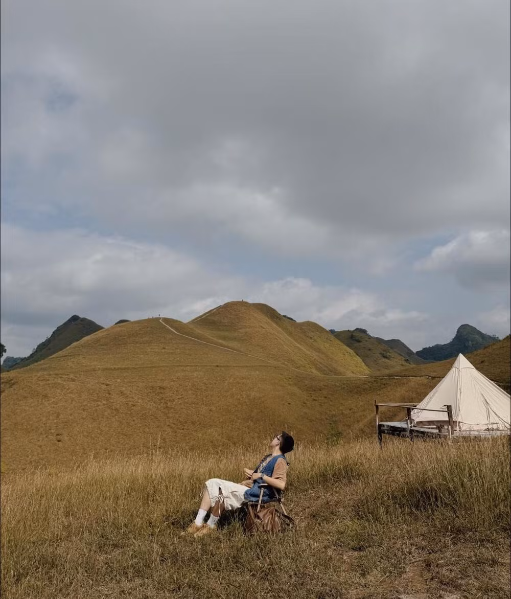 Bước sang tháng 11, đồi Ba Quáng chuyển mình trong sắc vàng của mùa cỏ cháy. Gió lạnh ùa về, cỏ vàng cam phủ kín sườn đồi nối tiếp nhau, tạo nên cảnh quan tự nhiên sống động như cả không gian được “nhuộm vàng” trong nắng thu. Ảnh Hữu Minh