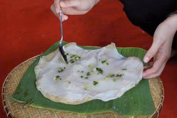 Cái tên “bánh tráng đập” không chỉ bắt nguồn từ cách chế biến mà còn thể hiện đúng tinh thần vui nhộn của món ăn. Người bán sẽ lấy một miếng bánh tráng nướng giòn rụm, sau đó đặt lên trên một lớp bánh ướt mềm dẻo, rồi dùng tay đập nhẹ để hai lớp dính chặt vào nhau. Ảnh danviet