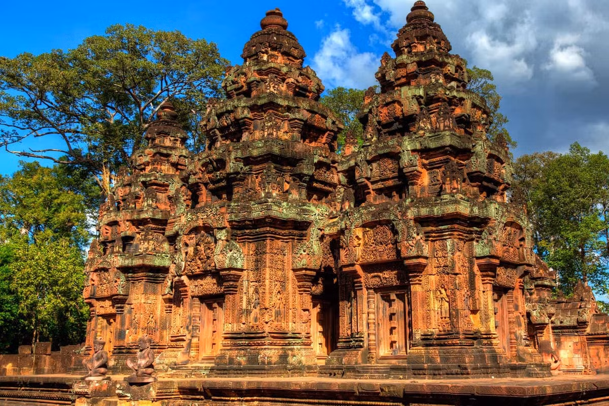 Nếu yêu thích nghệ thuật, Banteay Srei – còn gọi là “viên ngọc hồng” của Campuchia – sẽ khiến du khách ngỡ ngàng. Ngôi đền nhỏ được xây bằng đá sa thạch đỏ, nổi bật với những đường chạm khắc tinh vi đến mức nhiều nhà nghiên cứu gọi đây là “bản giao hưởng hoàn hảo của đá và ánh sáng”. Ảnh iVIVU