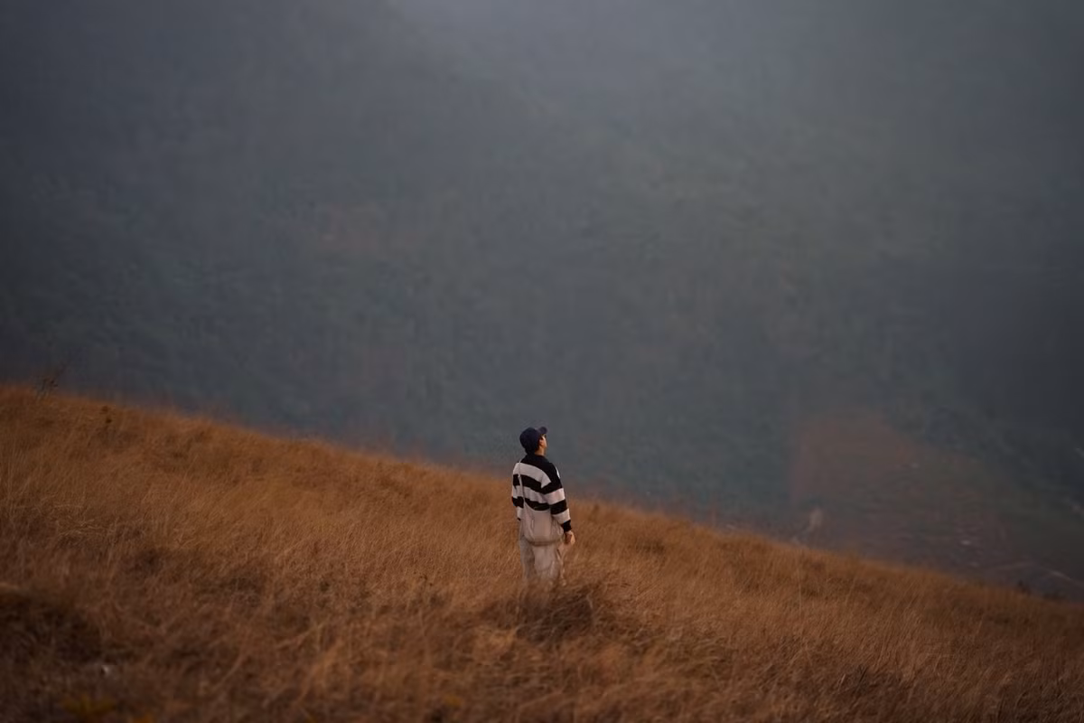 Không ít bạn trẻ lựa chọn đến đây bằng xe máy, trải nghiệm cảm giác chinh phục những cung đường đất đỏ uốn lượn, hai bên là đồi cỏ và thông xanh thưa thớt. Càng lên cao, không gian càng mở rộng, tầm nhìn bao trọn núi non trùng điệp, mang lại cảm giác tự do và khoáng đạt.