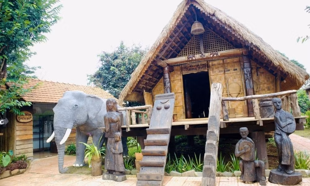 Trên diện tích hơn 62 ha, buôn có gần 250 hộ dân, trong đó người Ê Đê chiếm phần lớn. Điểm đặc biệt nhất là 32 ngôi nhà dài – biểu tượng văn hóa của dân tộc Ê Đê. Trước mỗi nhà đều đặt tấm ván khắc hình phụ nữ, tượng trưng cho vị thế mẫu hệ trong đời sống buôn làng. Dọc lối đi, các cổng nhà chạm khắc cảnh lễ hội, lao động, điệu múa… khiến cả buôn như một bảo tàng văn hóa ngoài trời. Ảnh MIA