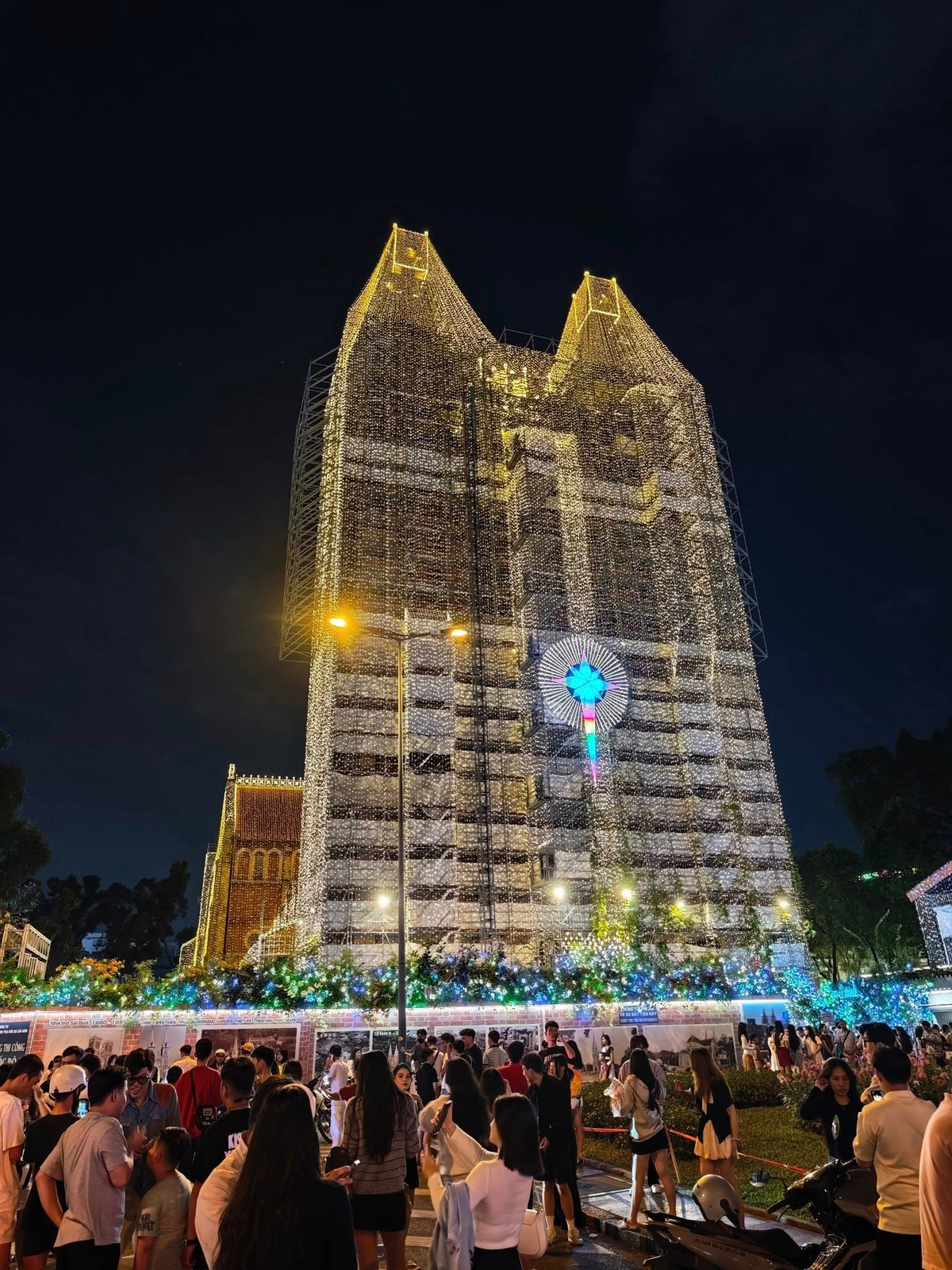 Không gian xung quanh nhà thờ trở nên huyền ảo, tạo phông nền hoàn hảo cho những bức ảnh Giáng sinh. Dòng người đổ về từ chiều tối để chiêm ngưỡng và lưu giữ khoảnh khắc bên công trình hơn 140 năm tuổi. Ảnh Toan Dominico