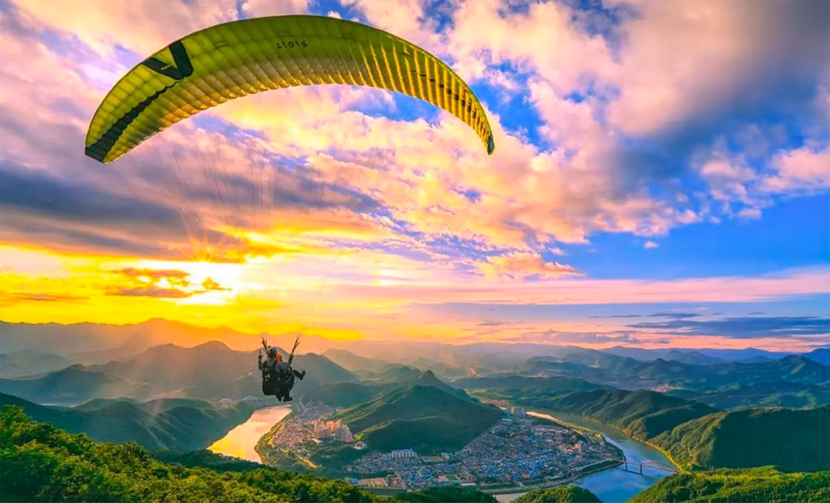 Nếu muốn thử cảm giác phiêu lưu, Danyang chính là điểm đến không thể bỏ qua. Nổi tiếng với hoạt động dù lượn, nơi đây cho phép du khách bay lượn giữa không trung, ngắm toàn cảnh núi non và rừng cây rực rỡ sắc thu. Dù du khách chưa từng có kinh nghiệm, đội ngũ hướng dẫn chuyên nghiệp sẽ giúp mọi thao tác trở nên an toàn và dễ dàng. Ảnh Vietravel