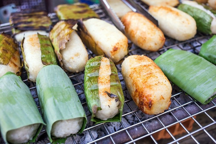 Khép lại danh sách là chuối nếp nướng, món ăn đường phố quen thuộc nhưng đòi hỏi sự tỉ mỉ trong chế biến. Chuối chín được bọc trong lớp nếp dẻo, nướng trên than hồng đến khi lớp ngoài vàng giòn, dậy mùi thơm. Khi ăn, chuối được cắt miếng, chan sữa dừa ấm và rắc thêm đậu phộng rang giã nhỏ. Sự hòa quyện giữa vị ngọt tự nhiên của chuối, độ béo của sữa dừa và độ dẻo dai của nếp tạo nên trải nghiệm ẩm thực mộc mạc nhưng giàu cảm xúc. Ảnh guide.michelin