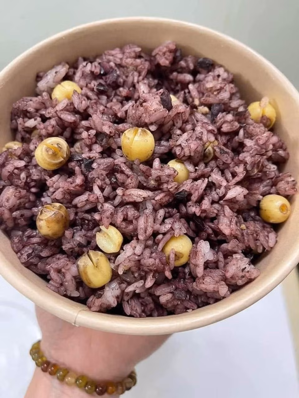 Xôi nếp nương đồ chín một lần, trộn cùng trám rim, rồi đồ thêm lần hai để hạt xôi ngấm đều vị. Thành phẩm là món xôi dẻo thơm, óng mỡ, thoang thoảng mùi trám và hành phi, ăn một lần là nhớ mãi. Ảnh Tapchidulichtphcm