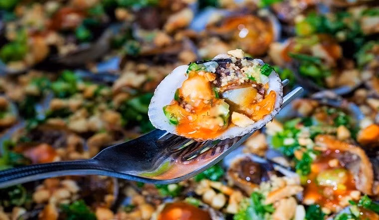 Sò huyết nướng mỡ hành là một món ăn rất phổ biến tại Cửa Lò. Sò huyết tươi ngon được nướng với mỡ hành thơm lừng, khi ăn có vị ngọt tự nhiên, kết hợp với hương mỡ hành béo ngậy. Đây là món ăn đơn giản nhưng mang lại cảm giác thích thú cho thực khách, đặc biệt là những ai yêu thích hải sản. Ảnh dulichnghean