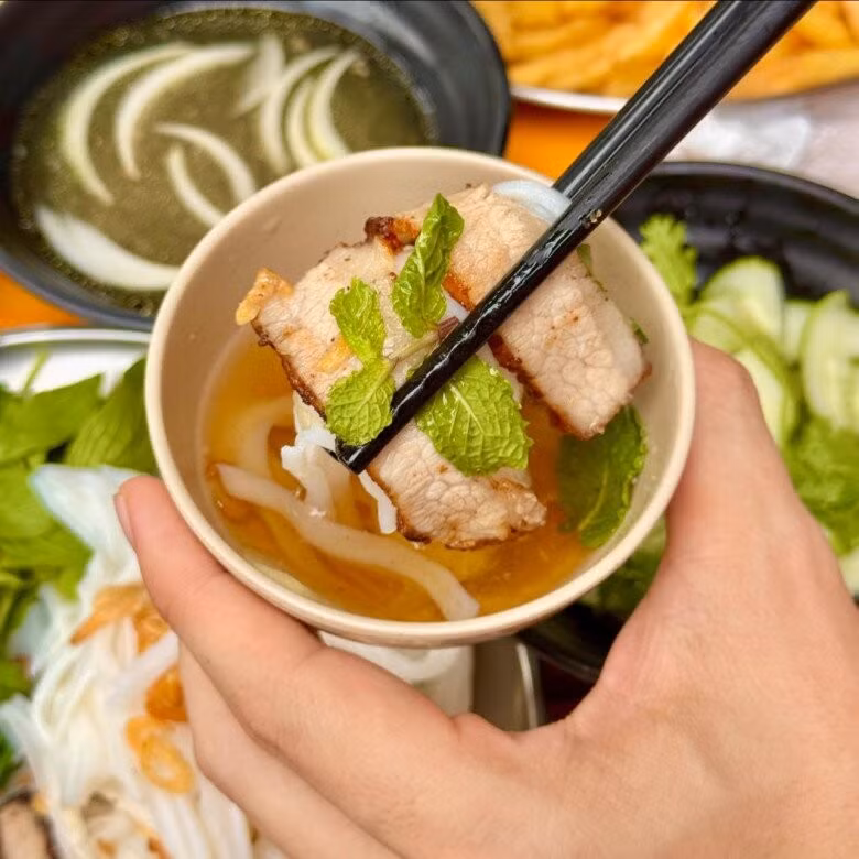 Một phần phở chấm xíu gồm bánh phở tươi, thịt xíu thái lát, rau sống và bát nước chấm nóng hổi. Chỉ cần gắp phở, kèm miếng thịt, chấm ngập nước, du khách sẽ cảm nhận hương vị hòa quyện tinh tế – vừa dân dã, vừa mới lạ. Ảnh checkinvietnam