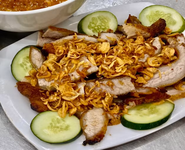 Chiều muộn, các quán phở chấm xíu trên phố Nguyễn Hiền luôn đông kín. Mùi thịt xíu lan tỏa, tiếng rán xèo xèo hòa cùng tiếng trò chuyện tạo nên một không gian ẩm thực đặc trưng của Thành Nam về đêm. Ảnh checkinvietnam