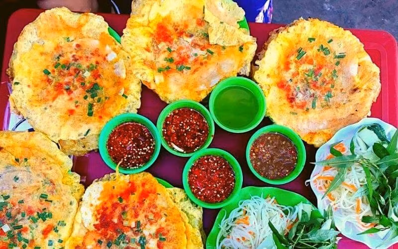 Nếu du khách muốn tìm món ăn vặt “đậm chất học trò” thì bánh ép chị Xí ở kiệt Nhật Lệ là địa chỉ không thể bỏ qua.Chỉ với 2.000 – 5.000 đồng/chiếc, du khách đã có ngay chiếc bánh ép nóng hổi, nhân thịt thơm lừng, ăn kèm nước mắm chua ngọt cay cay và đu đủ ngâm. Quán thường mở cửa vào buổi chiều, đông nghịt học sinh – sinh viên đến ăn và trò chuyện. Ảnh amthuc