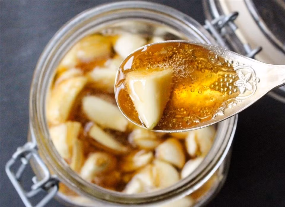 Một công thức được nhiều người ưa chuộng khác là tỏi ngâm mật ong. Sự kết hợp giữa hai nguyên liệu tự nhiên này tạo nên hỗn hợp có khả năng kháng khuẩn, giảm viêm và điều hòa đường huyết hiệu quả. Ảnh minh họa